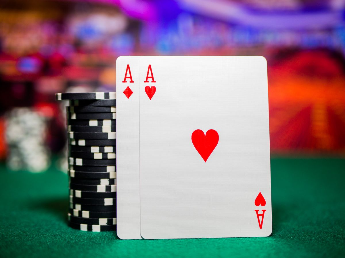 Kartu remi dan chip poker di atas meja hijau