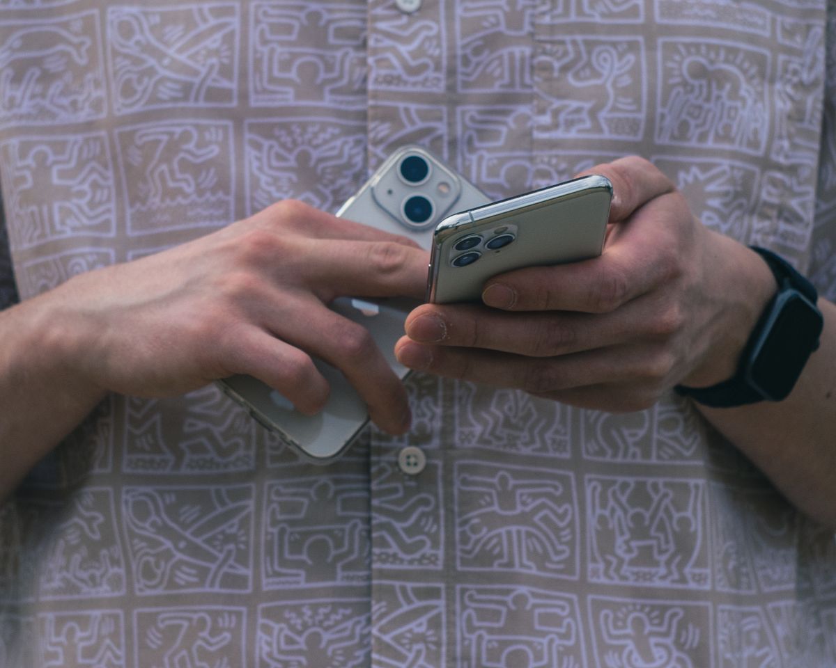 Dua ponsel pintar dipegang pengguna untuk bermain game mobile